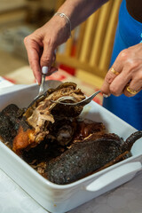 Traditional Sardinian suckling pig, artisanally cooked at home with potatoes on a family table.