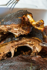 Traditional Sardinian suckling pig, artisanally cooked at home with potatoes on a family table.