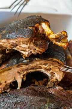 Traditional Sardinian suckling pig, artisanally cooked at home with potatoes on a family table.