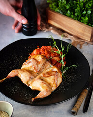 The Grilled Quail dish is beautifully presented with fresh vegetables