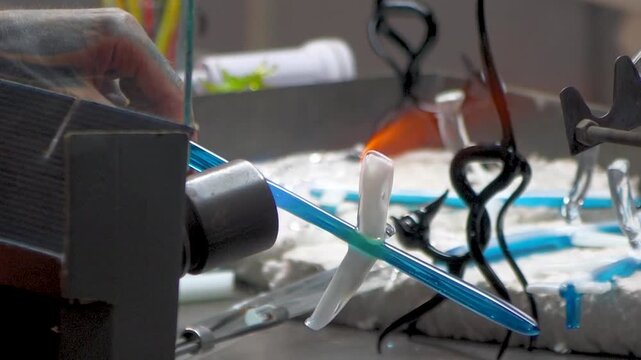 hands of a mand creating crystal decoration fith hot fire at glass foundry 