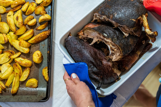 Traditional Sardinian suckling pig, artisanally cooked at home with potatoes on a family table.