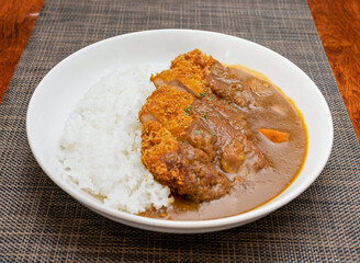 Japanese Chicken Katsu Curry with Rice on a White Plate isolated on mat side view of Asian cuisine