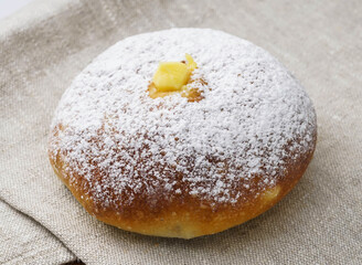 Custard Cream Bun bread with Powdered Sugar on Fabric mat side view of a Classic Japanese Pastry