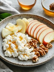Healthy breakfast plate featuring sliced apples, cottage cheese, walnuts, and honey drizzled on top served in a cozy kitchen setting