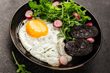 Eggs breakfast black pudding, egg, vegetables, arugula portion size natural product tasty snack fresh delicious gourmet food background on the table rustic top view copy space
