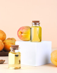 Bottles of apricot oil with ripe apricots on pastel background. Organic skincare and natural beauty treatment concept.
