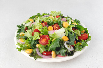 Green salad with fresh vegetables and lupine beans on white background. Vegetarian food.