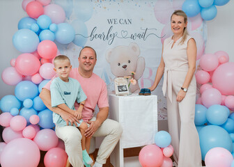Family group shot in pastel balloon decor at a baby-shower