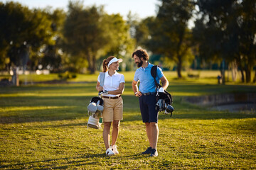 Fototapeta premium Happy couple of golfers talking on golf course.