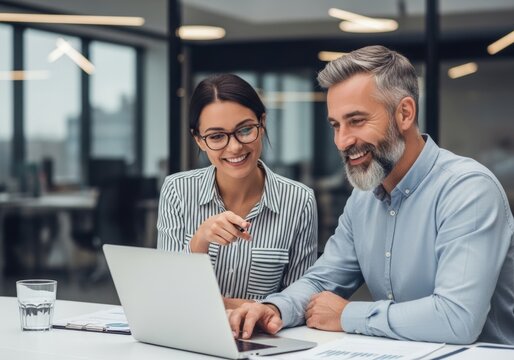 Diverse business team collaborating on laptop in modern office environment achieving success together
