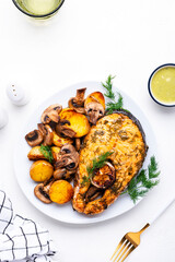 Yummy dinner with grilled salmon, baby potatoes and mushrooms with creamy garlic sauce on white table, top view