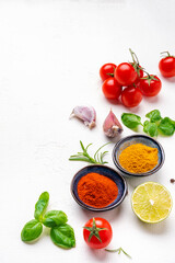 Eat healthy, cook delicious. Food background, spices, basil, rosemary, tomato - ingredients for healthy eating and cooking, white copy space, top view