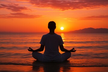 Silhouette meditating at sunset over calm ocean waters
