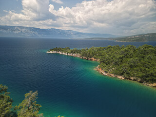 The stunning Mediterranean coastline near Antalya Turkey viewed from high altitude showcasing turquoise waters meeting golden sandy beaches and rugged cliffs surrounded by pine forests