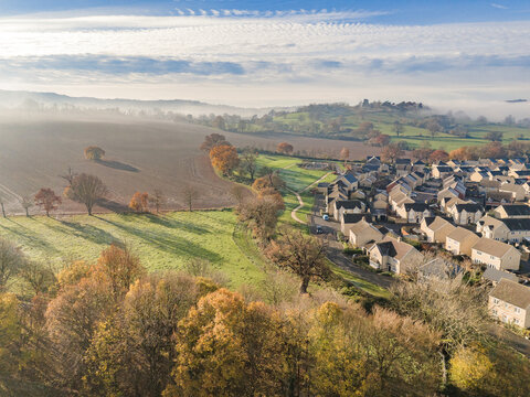 A drone view of a contemporary housing estate with fields and countryside