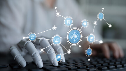 A close-up of a robotic hand hovering over a keyboard, interacting with a digital interface featuring icons, symbolizing technology, automation, and modern connectivity. Tessel