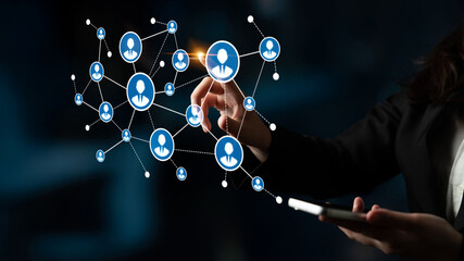 A business professional uses a smartphone to interact with a digital network of connections, symbolizing the role of technology in modern communication and innovation. Tessel