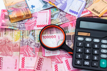 Indonesian Rupiah Currency Detailed Analysis with Magnifying Glass and Calculator Represents Financial Planning Investment Banking and Economic Concepts in Indonesia Economy
