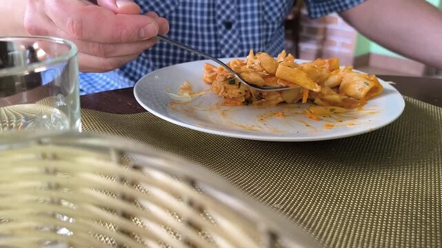 Rekaman seorang pria sedang makan spageti di meja