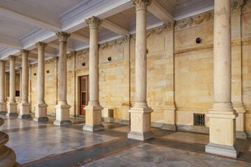 Fototapeta premium Historic colonnade with marble columns and intricate ceiling in classical architecture setting