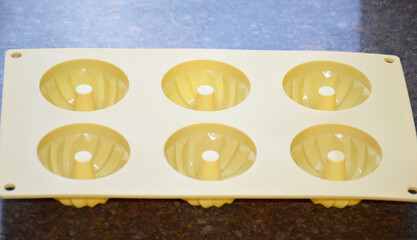 Silicone molds for baking cupcakes or puddings. Each cavity is round with textured sides and a cone-shaped ridge in the center, making it ideal for baking cupcakes, donuts, or mini bundt cakes