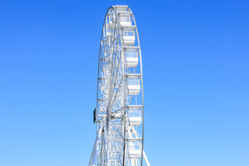 Giant ferris wheel against clear blue sky on a sunny day