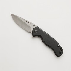Folding knife with black handle on light background  