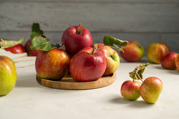 Freshly picked red apple in a wooden plate, bright rustic background