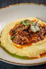 Mashed potatoes with beef stew and herbs.