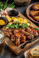 Grilled meat and sausages with potatoes and sauces.