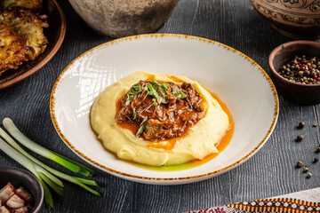 Mashed potatoes with beef stew and herbs.