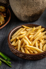 French fries in a rustic ceramic bowl.