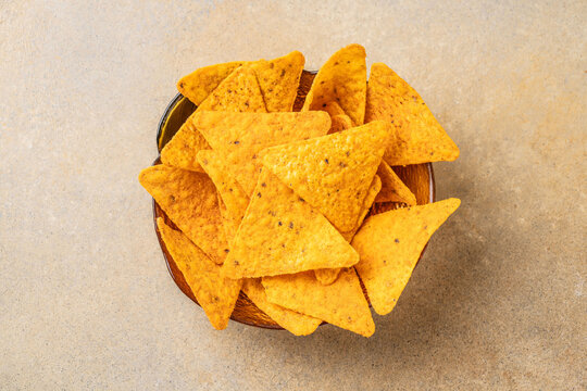 Mexican tortilla chips in wooden bowl on stone surface - Powered by Adobe