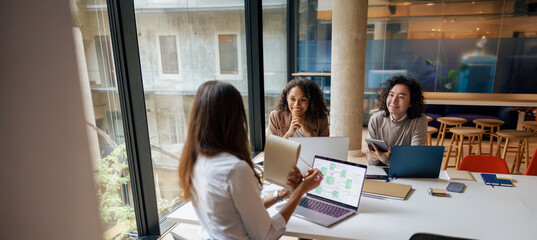 In a modern and vibrant workspace, three skilled professionals are engaging in a dynamic, insightful discussion