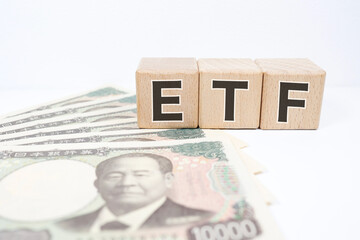 ETFの文字と一万円札、資産運用と投資のイメージ。