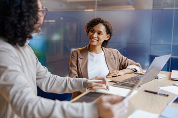 Two colleagues engage in a productive discussion at a modern office table, highlighting teamwork and collaboration