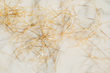 mess, tangle of golden thread on white marble