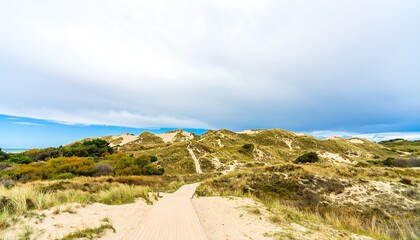 Sand dunes pathway leading to a hill