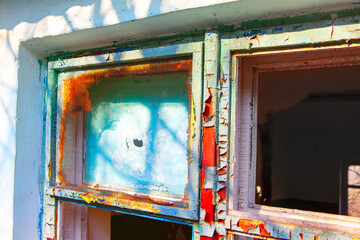 Weathered window frame with peeling paint, revealing layers of history and texture. Perfect for...