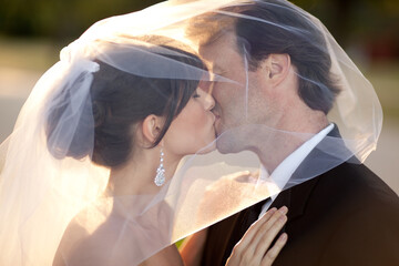 Romantic Bride and Groom Kissing Behind Wedding Veil Outside - Romantic Moment 