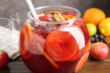 Tasty punch and fruits on wooden table, closeup. Refreshing drink