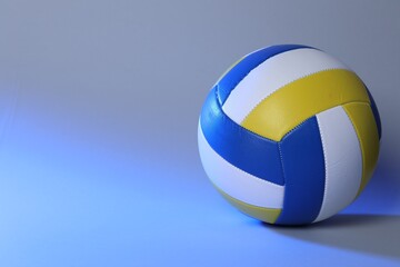 Colorful volleyball ball on blue background. Space for text