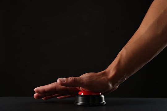 Man pressing button on black background, closeup. Space for text
