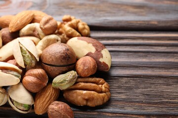 Mix of different nuts on wooden table, closeup. Space for text