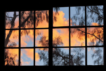 window bathed in ultrabright hues of sunset casting intricate patterns of light and shadow