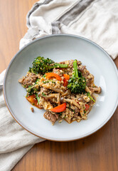 Close up of Healthy One Pot Meal of Ground Bison, Mushrooms, Broccoli, Barley, and Quinoa with Fresh Herbs