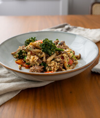 Close up of Healthy One Pot Meal of Ground Bison, Mushrooms, Broccoli, Barley, and Quinoa with Fresh Herbs