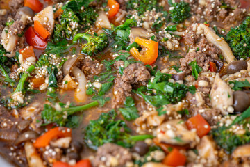 Close up of Healthy One Pot Meal of Ground Bison, Mushrooms, Broccoli, Barley, and Quinoa with Fresh Herbs