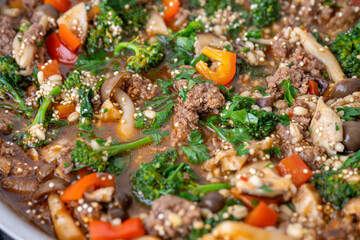 Close up of Healthy One Pot Meal of Ground Bison, Mushrooms, Broccoli, Barley, and Quinoa with Fresh Herbs